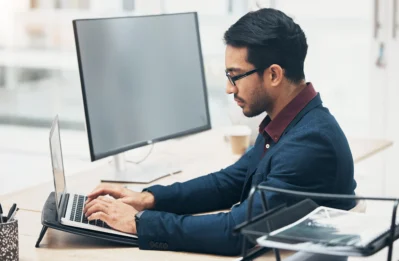 Homem mexendo no computador, aprendendo como gerar boleto para cliente no Asaas.