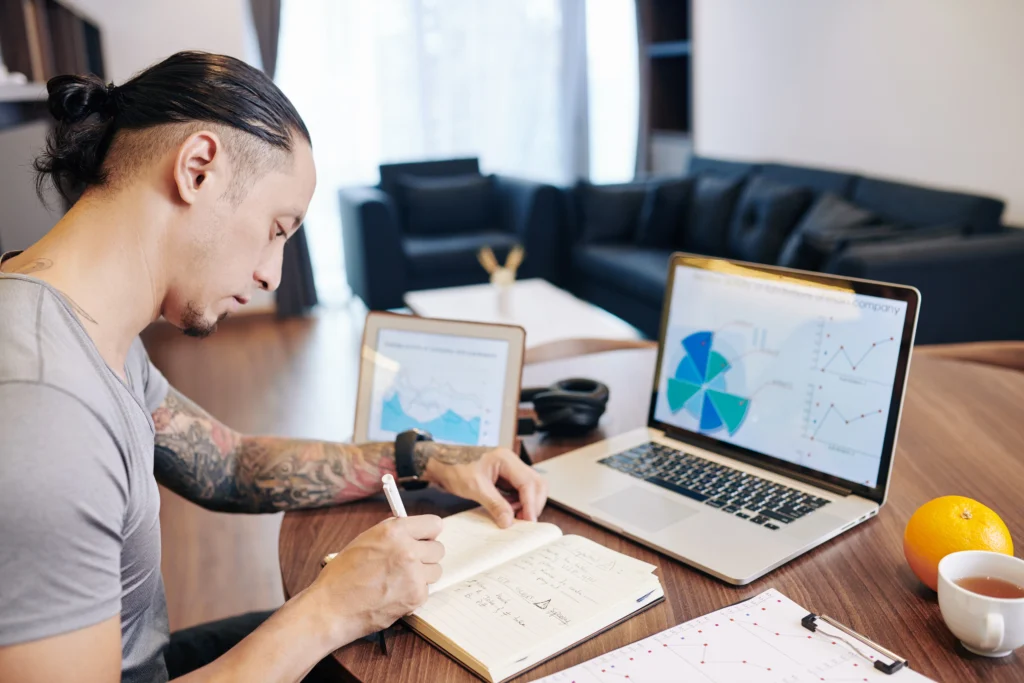 Empreendedor analisando informações sobre receitas, enquanto realiza o controle de pagamento de clientes.