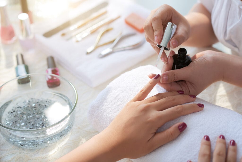 Na imagem, temos uma manicure fazendo as unhas de uma cliente. Elas estão conversando sobre parcerias, que também faz parte do marketing para manicure