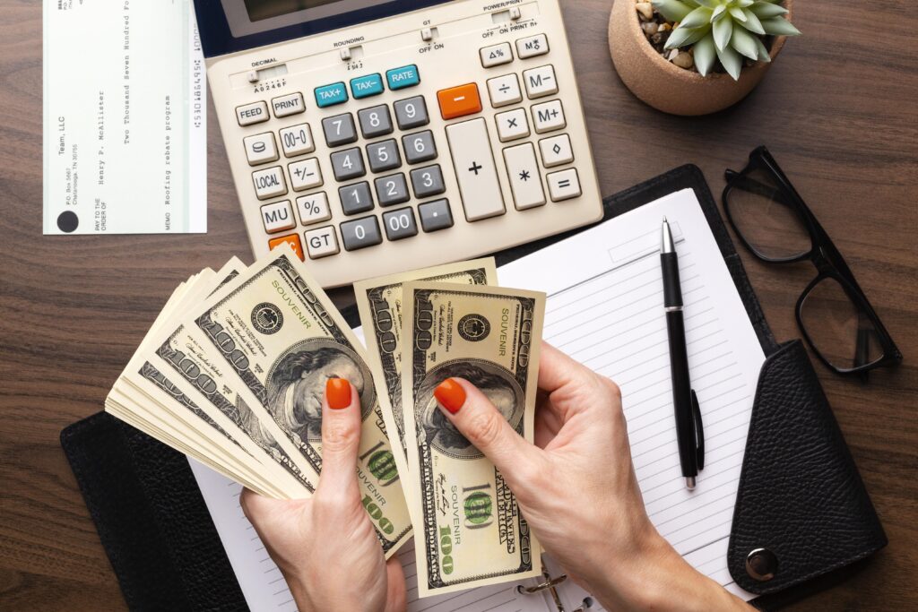 Uma empreendedora está contando algumas notas de dinheiro, separando o Lucro Real e Lucro Presumido