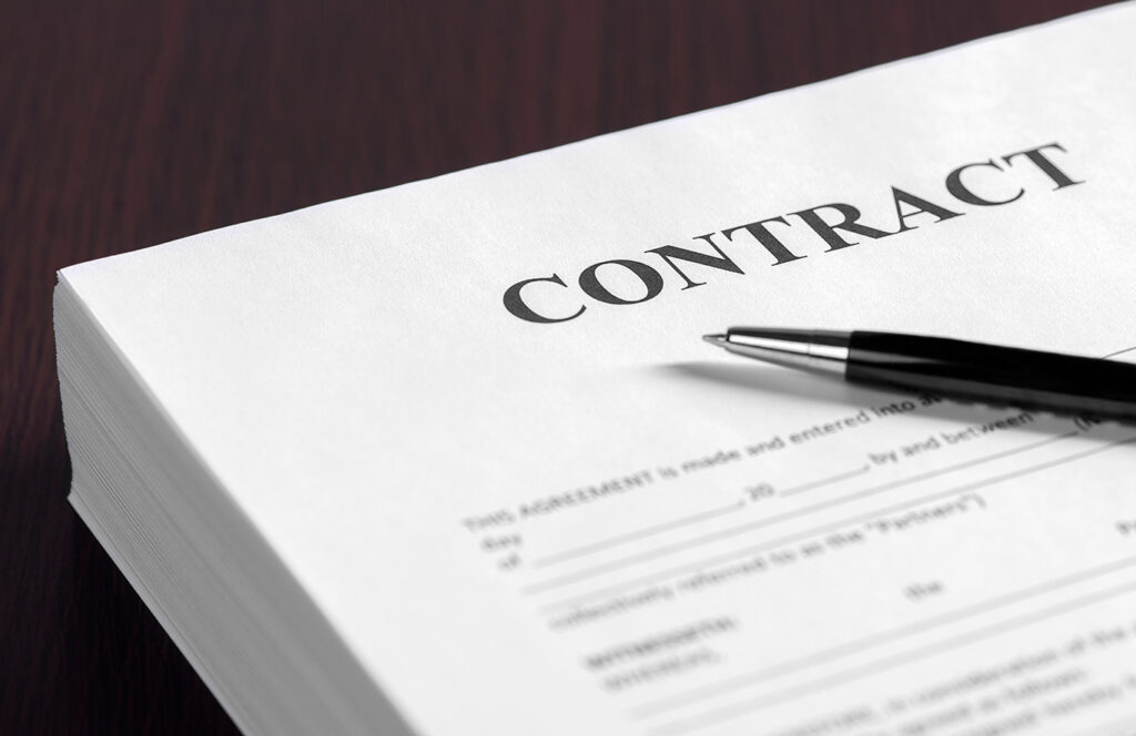 Na imagem, temos alguns contratos em cima de uma mesa. isso representa como fazer uma rescisão de contrato.