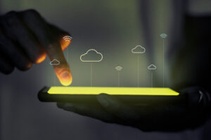 Na imagem, temos um celular com alguns símbolos de nuvens e wi-fi. Isso representa a cloud computing