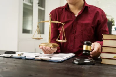 Homem segurando uma balança dourada em uma mão e em outra um martelo de juiz, simbolizando a cobrança judicial.