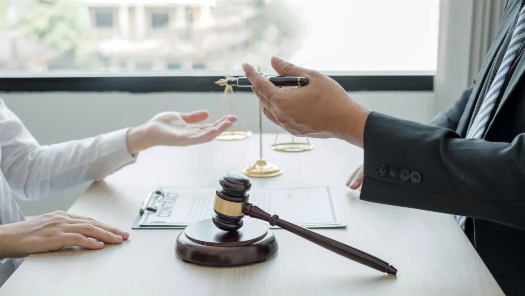 Mãos sobre a mesa, com martelo de justiça, representando Como funciona a cobrança judicial de dívida.