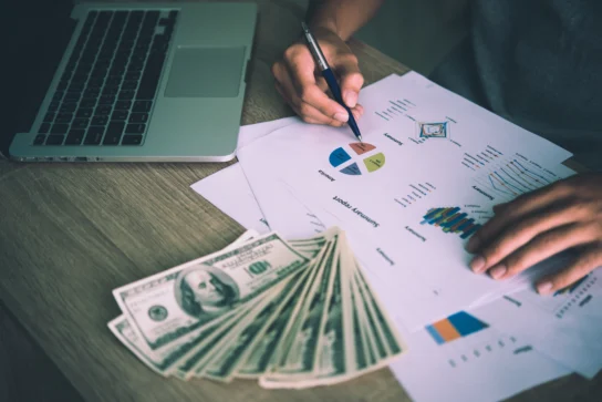 Empreendedora realizando conferência nos fluxos de caixa enquanto faz a gestão de cobranças da empresa.