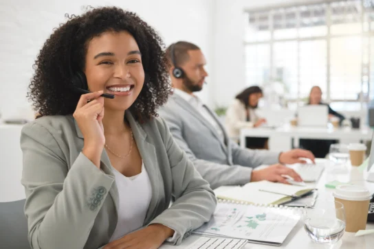 Operadora de telemarketing sorri para a câmera enquanto realiza cobrança extrajudicial.