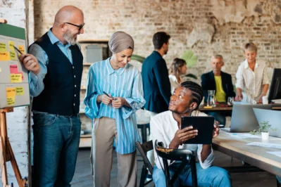 Gestores verificando os índices de inadimplência da empresa, enquanto debatem sobre o uso de um sistema de cobrança de inadimplentes.