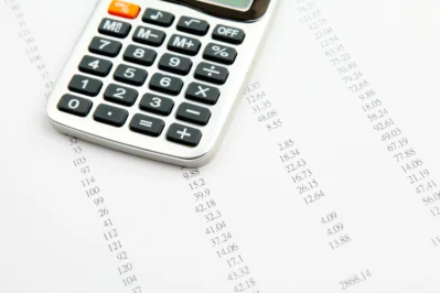 Imagem de uma calculadora e muitas contas, representando o controle de contas a pagar.