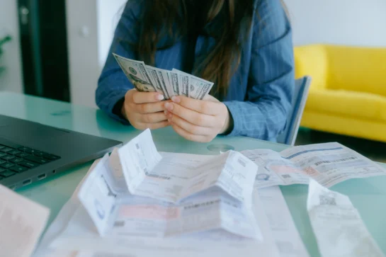 Empreendedora realizando contas de recebimentos e de clientes inadimplentes.