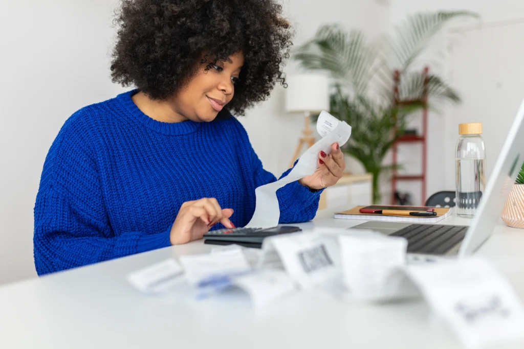 Empreendedora realizando a conferência de suas contas para ter previsão de recebimentos de seu caixa.