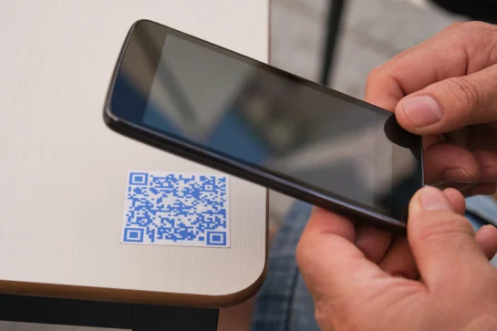 Cliente apontando câmera do celular para QR Code, aprendendo como funciona o Pix.