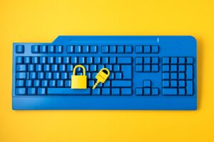 Teclado de computador azul com uma chave e um cadeado fechado encima, representando a forma como o pix é seguro.
