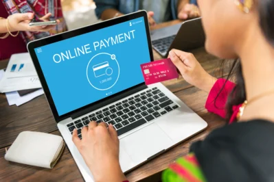Pessoa usa notebook escrito "online payment" na tela com um cartão de crédito na mão. A imagem representa o uso da API de pagamento para processos de venda online.