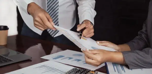 Gestores estudando qual a melhor plataforma de antecipação de recebíveis ao analisarem gráficos.