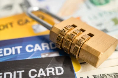 A imagem contém 3 cartões de crédito, de cores diferentes. Em cima, há um cadeado, simbolizando a segurança que a certificação PCI DSS oferece.