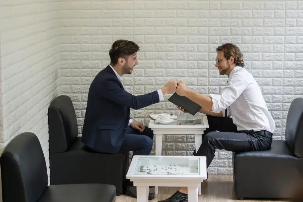 Empresário entregando pasta para cliente, aprimorando suas formas de como cobrar um cliente.