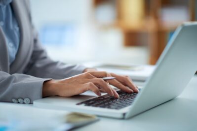 Na imagem, temos um homem mexendo em seu computador. Ele está enviando mensagens, aprendendo como cobrar um cliente.