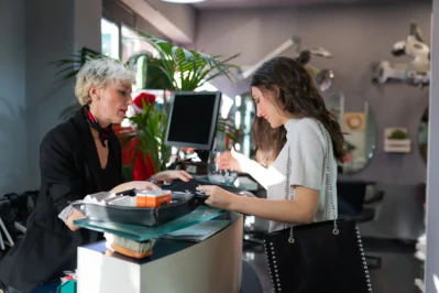 Mulher sorri enquanto realiza pagamento, demonstrando o processo de como cobrar um cliente para diminuir a inadimplência.