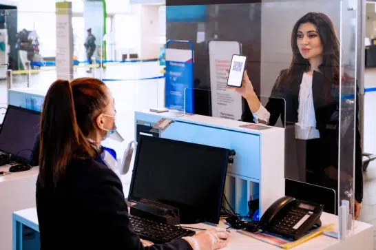 Empreendedora na boca de um caixa realizando uma transação, após escolher qual o melhor banco para empresa LTDA.