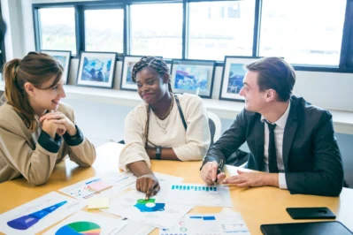 Equipe reunida analisando gráficos e relatórios, representando na prática o que é gestão financeira.