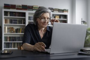 Uma diretora está pesquisando sobre gestão financeira escolar no computador de sua sala.