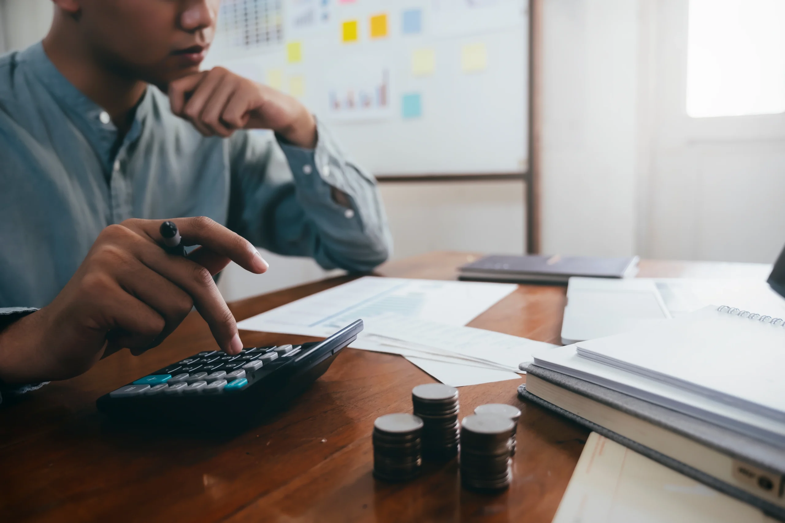 Pessoa analisando documentos e finanças, pensando em como saber se o boleto é falso.