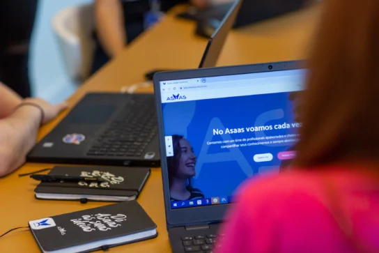 Menina em frente ao computador, na tela está o sistema de emissão de boleto.