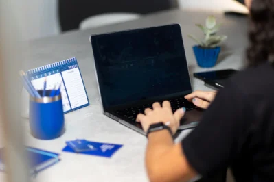 Mãos sobre o teclado do notebook, buscando Emissor de nota fiscal