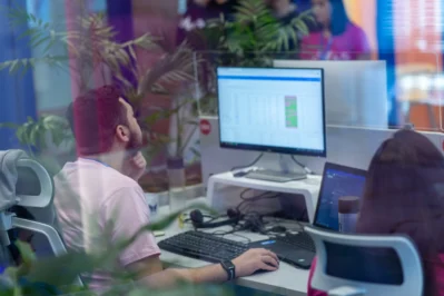 Homem no escritório, sentado em frente ao computador, buscando o que é pagamento recorrente.