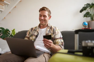 Home sorri pra o pc segurando um cartão, buscando Como funciona o pagamento de férias.