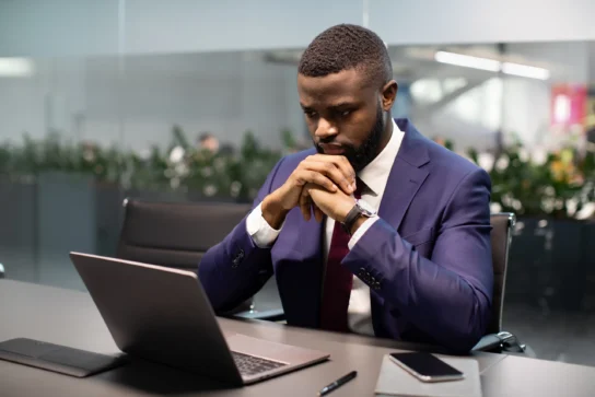 Homem negro de terno, busca no computador O que é CNPJ.