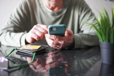 Homem busca o que é pagamento mensal no celular para aderir mensalidade de TV.