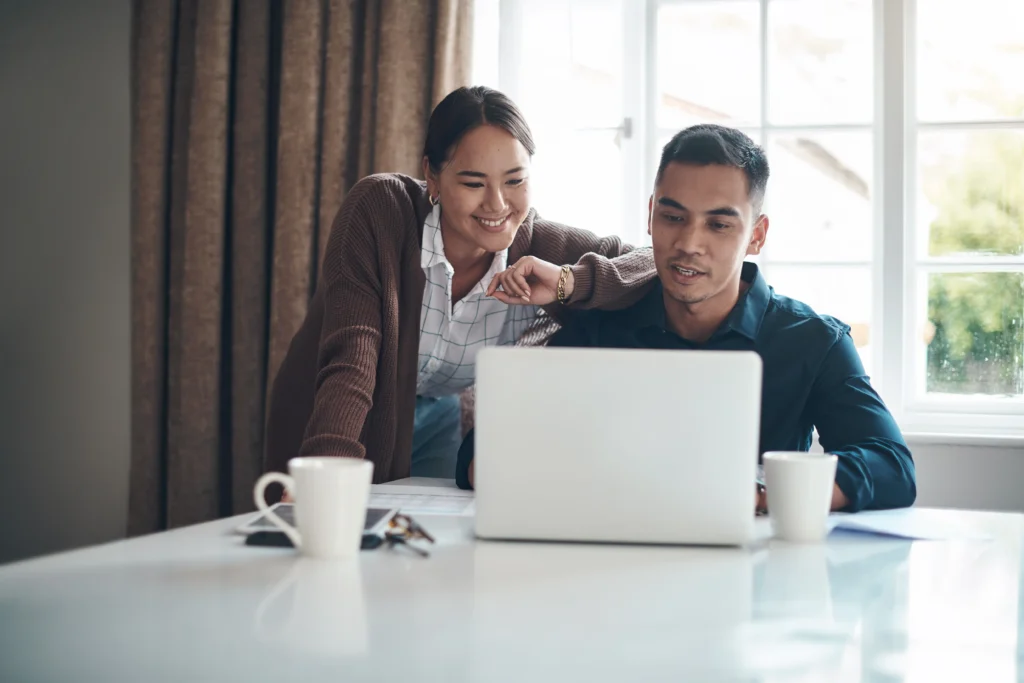 Dupla analisando dados no computador, representando como definir metas financeiras claras e alcançáveis.