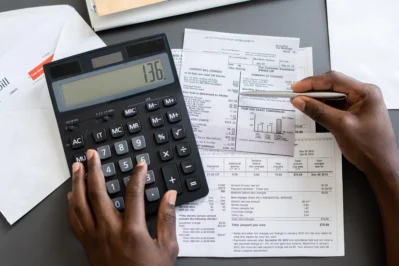 Pessoa usando calculadora de boleto para entender como calcular juros de boleto bancário e organizar as finanças.