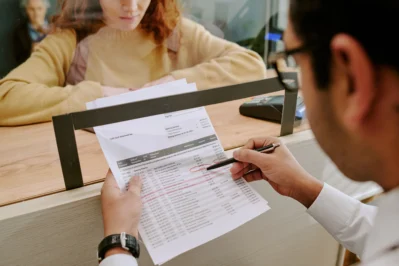 Cliente com documento na mão conferindo informações para aprender como gerar boleto para receber pagamento.