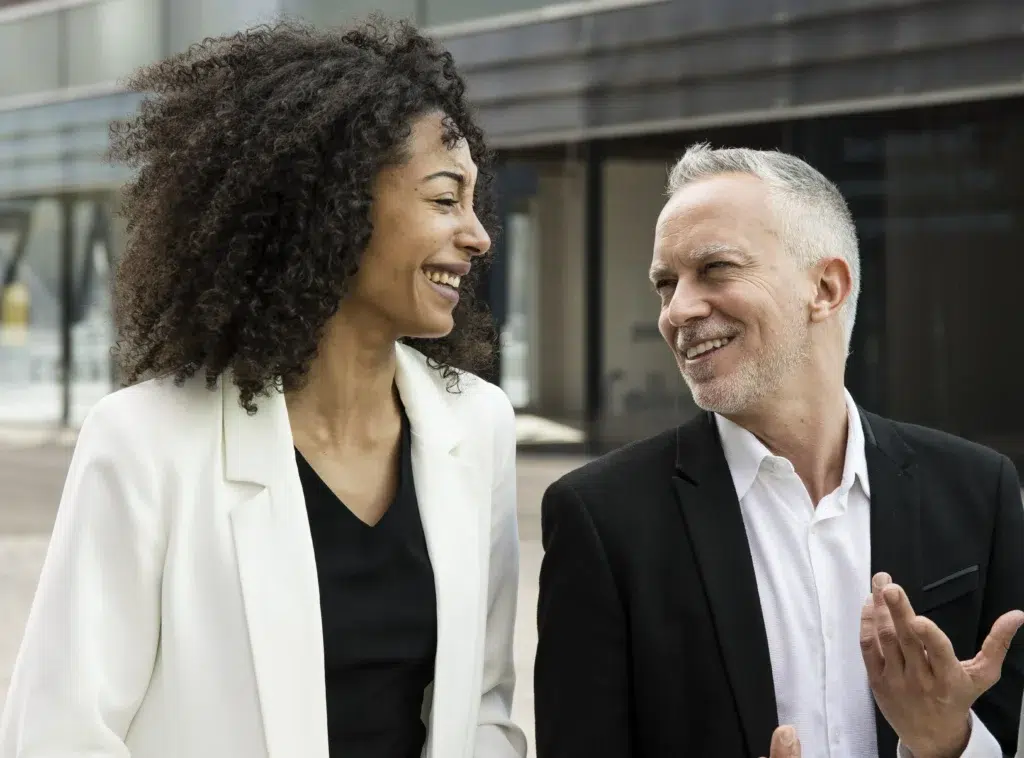 Dois sócios de uma empresa sorrindo olhando um para o outro, representando o processo de como abrir empresa LTDA.