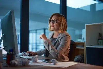 Empreendedora trabalhando até tarde, estudando formas de como conseguir capital de giro para empresa.