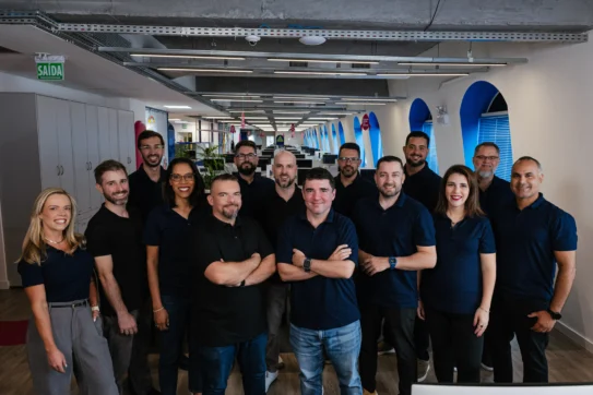 Reunião de equipe no Asaas com apresentação sobre a missão, visão e valores do Asaas em ambiente moderno e colaborativo.