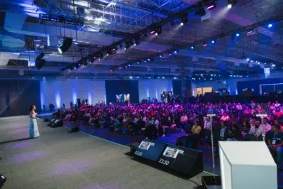 Foto de uma palestra para exemplificar os bastidores do Asaas Connect 2023, em que mostra uma palestrante e a plateia.