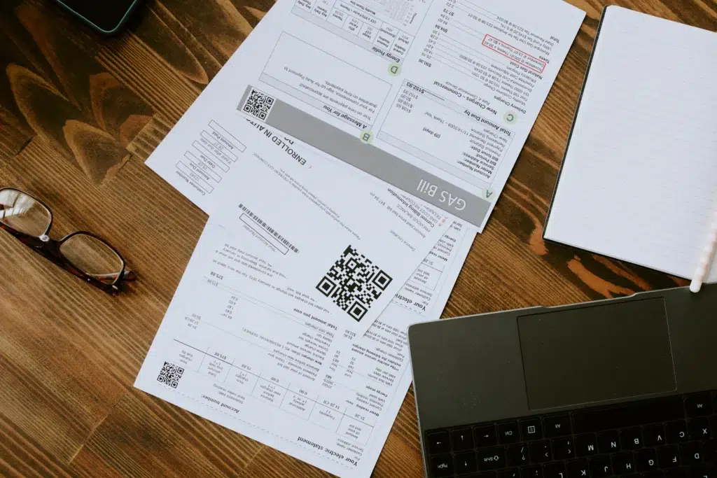 Mesa com boletos e computador, ilustrando organização financeira com boleto DDA.