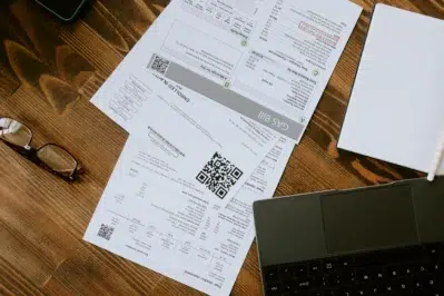 Mesa com boletos e computador, ilustrando organização financeira com boleto DDA.