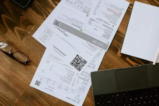 Mesa com boletos e computador, ilustrando organização financeira com boleto DDA.
