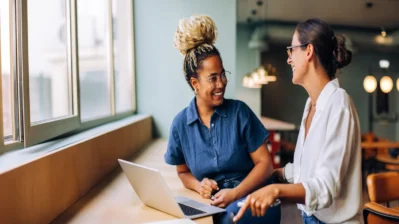 Duas mulheres sorrindo e conversando sobre os motivos para escolher o Asaas.