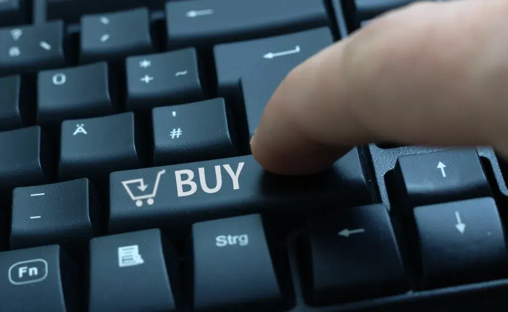 Tecla de computador com ícone de carrinho e palavra BUY, simbolizando compras online com tokenização Asaas.