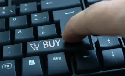 Tecla de computador com ícone de carrinho e palavra BUY, simbolizando compras online com tokenização Asaas.