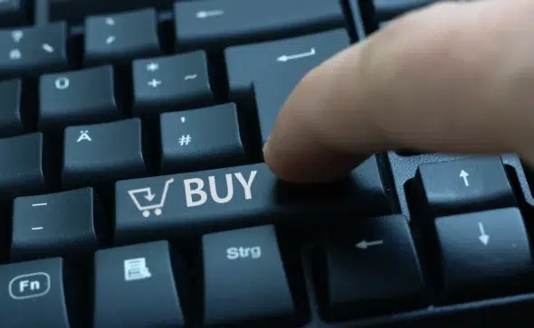 Tecla de computador com ícone de carrinho e palavra BUY, simbolizando compras online com tokenização Asaas.