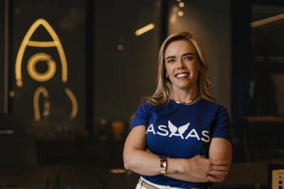 Manoela Gieseler, COO Asaas, de braços cruzados e utilizando camisa do Asaas, representando a diretoria da fintech.