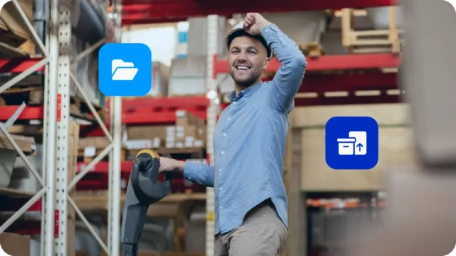 Homem vestindo camisa azul em trabalhando em armazém enquanto usa o material rico de planilha de controle de estoque do Asaas.