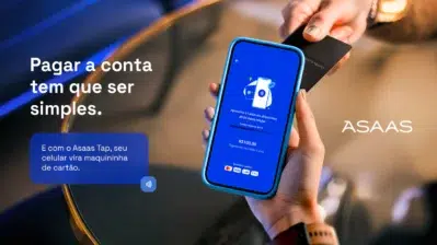 Mão segurando celular usando a nova funcionalidade Asaas Tap.