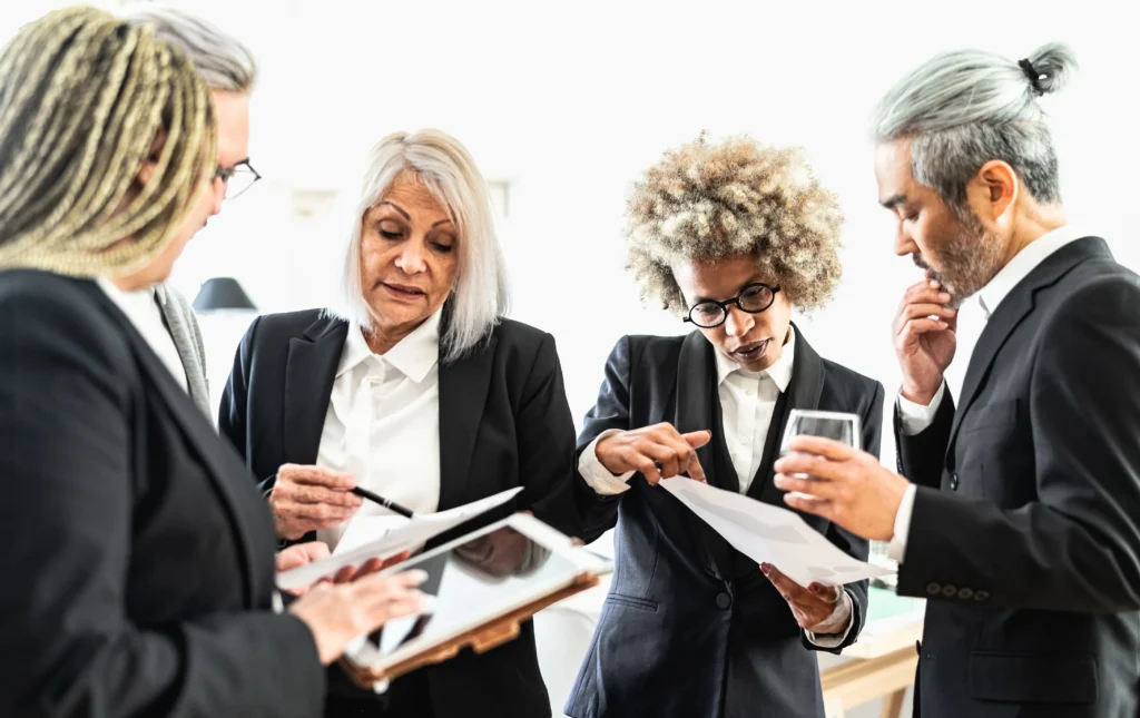 Qual tipo de empresa abrir e escalar? Conheça as 6 principais 2 Empresários pesquisando e conversando, aprendendo como saber qual tipo de empresa abrir.